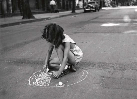 "Kleines Mädchen malt mit Kreide auf den Straßenasphalt"
